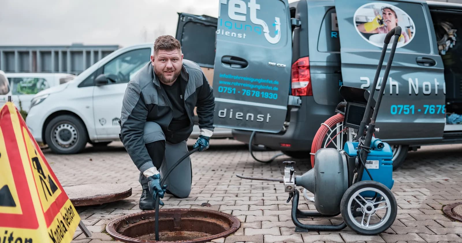 Mitarbeiter von Binfet Rohrreinigung am geöffneten Kanalschacht